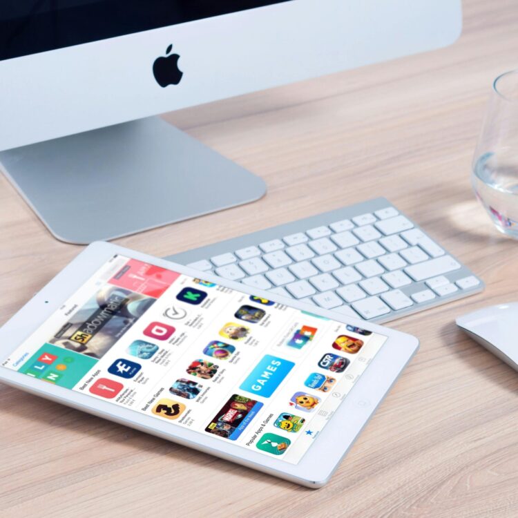 Sleek home office setup featuring an iMac and iPad showcasing apps.