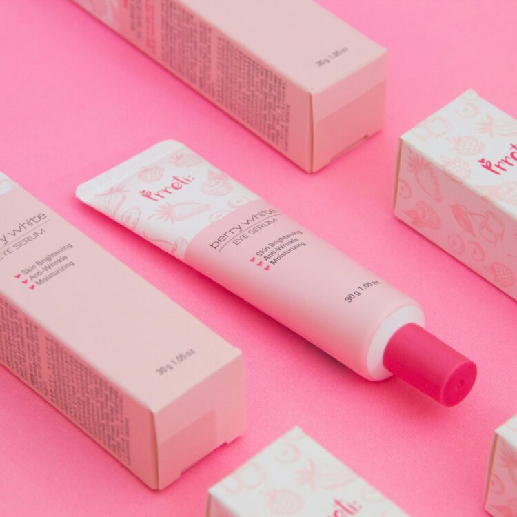 Pink-themed flat lay of berry-white eye serum with packaging.