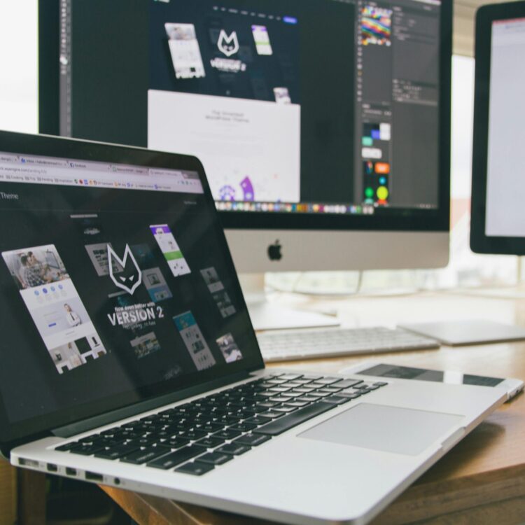 A stylish workspace featuring a laptop and monitors displaying design software.