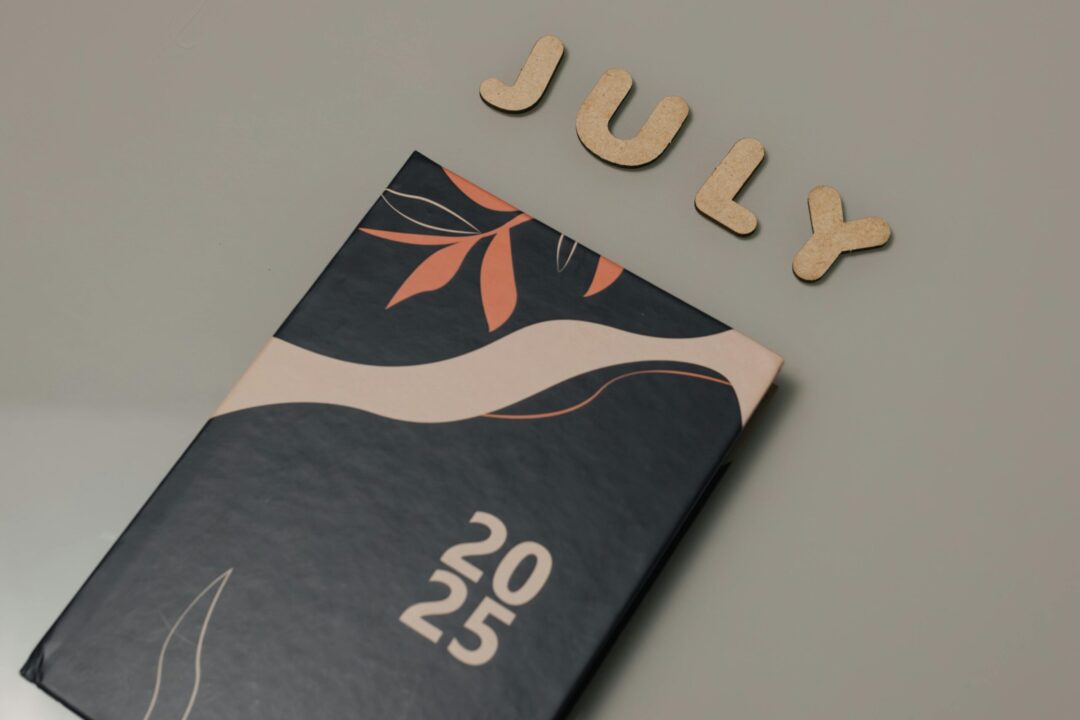 Close-up of a 2025 planner with July letters on a minimalist background.