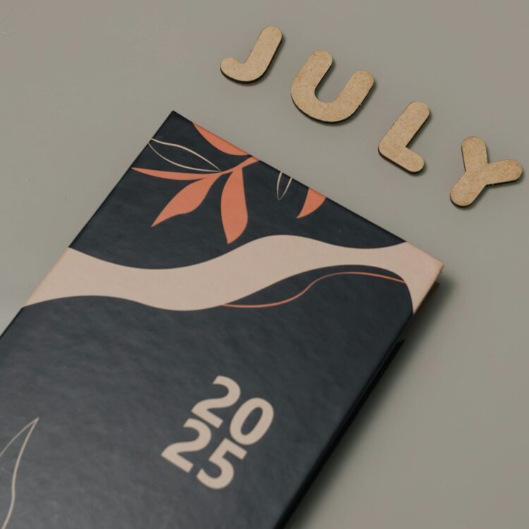 Close-up of a 2025 planner with July letters on a minimalist background.