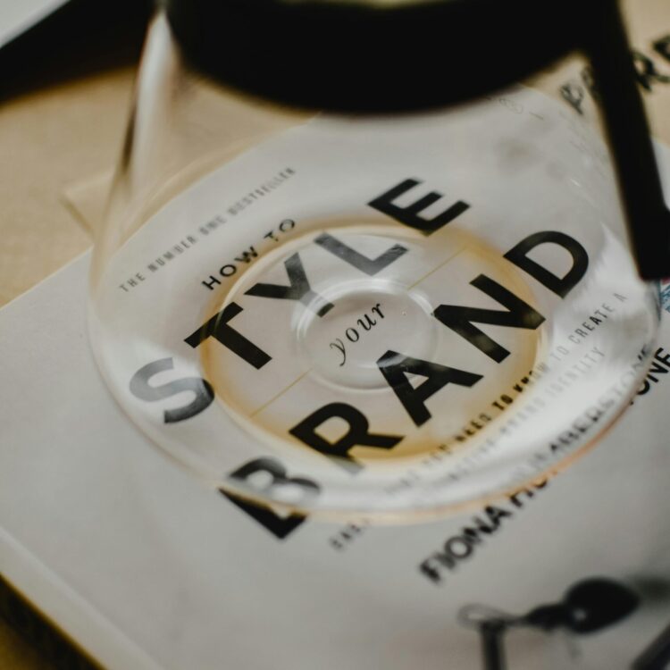 A coffee pot rests atop a book titled 'How to Style Your Brand', capturing the essence of creative branding.